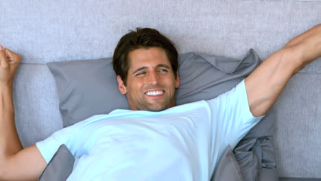 Tanned-man-waking-up-and-stretching-