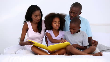 Family-reading-book-on-bed