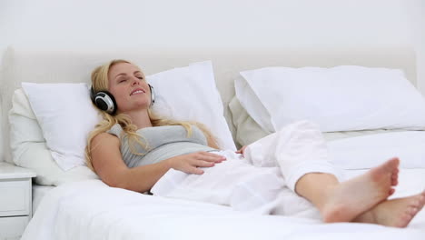 Blonde-woman-listening-to-music-on-bed