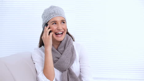 Smiling-young-woman-with-hat-and-scarf-calling-someone
