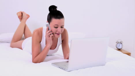 Beautiful-woman-phoning-while-using-her-notebook