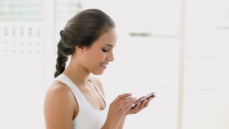 Fitte-Junge-Frau-Sendet-Eine-SMS-Auf-Dem-Smartphone