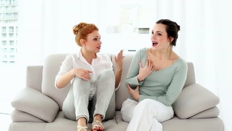 Two-attractive-women-fighting-sitting-on-couch-