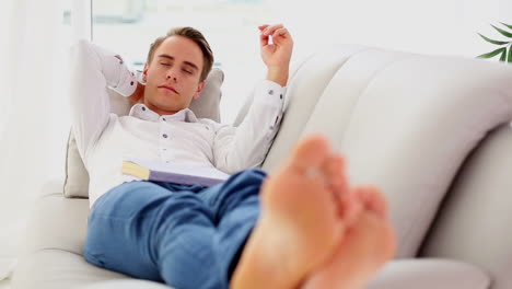 Attractive-young-man-lying-on-couch-while-sleeping