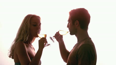 Couple-drinking-together-against-sunlight