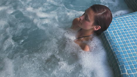 Brunette-relaxing-in-a-jacuzzi-pool