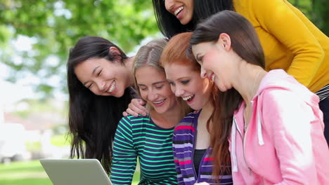 Estudiantes-Mirando-La-Computadora-Portátil-Juntos-Afuera-Y-Riendo