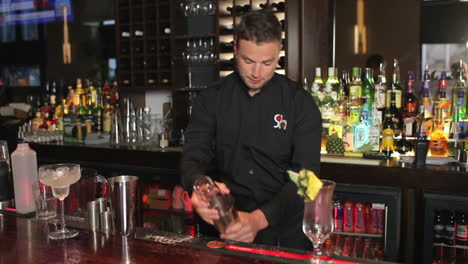 Handsome-bartender-shaking-drink-in-a-cocktail-shaker