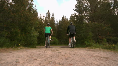 Fit-couple-mountain-biking-in-the-countryside-together-away-from-camera