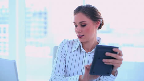 Concentrated-businesswoman-using-a-calculator