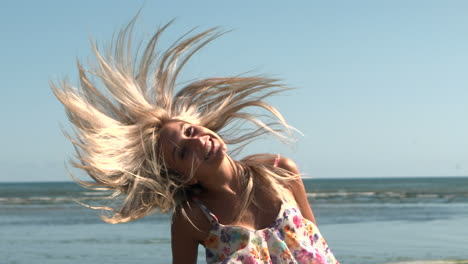 Happy-blonde-shaking-hair-on-the-beach