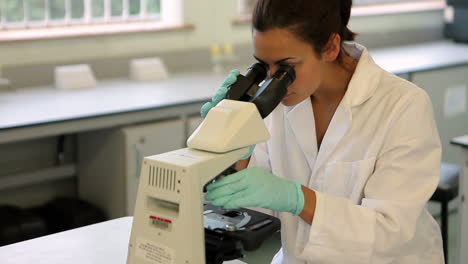 Science-student-looking-through-microscope-in-the-lab