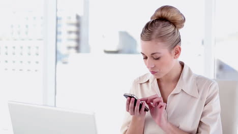 Happy-blonde-businesswoman-texting