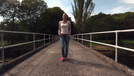 Casual-young-woman-walking-over-bridge