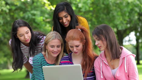 Alumnas-Mirando-La-Computadora-Portátil-Juntas-Afuera