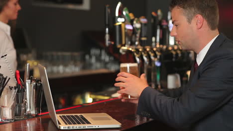 Hombre-De-Negocios-Trabajando-En-Su-Computadora-Portátil-Mientras-Toma-Una-Cerveza