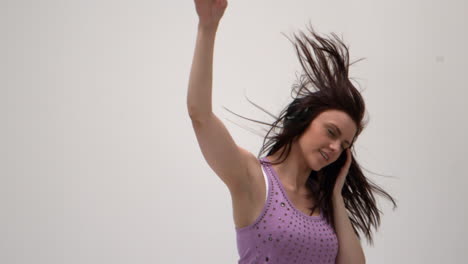 Cute-young-woman-jumping-while-listening-to-music