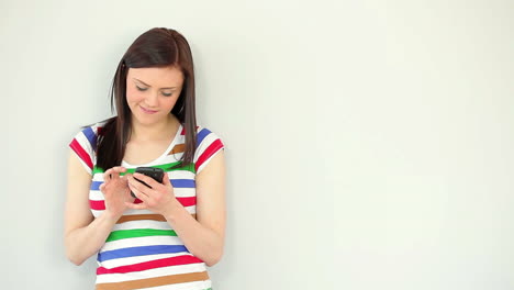Smiling-young-woman-texting-on-her-phone