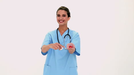 Content-beautiful-nurse-showing-red-pills-in-her-hand