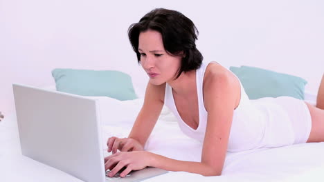 Amused-calm-woman-typing-on-her-laptop