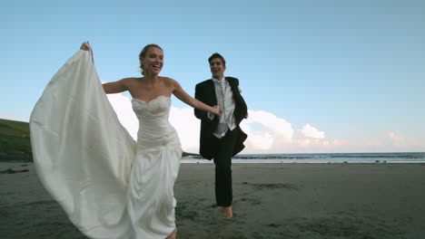 Feliz-Pareja-De-Recién-Casados-Corriendo-En-La-Playa