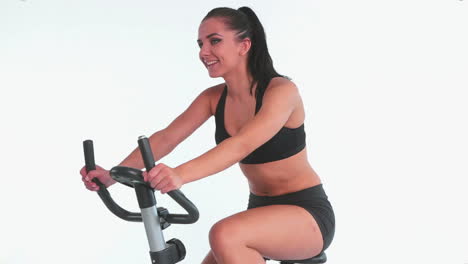 Sporty-cheerful-brunette-using-exercise-bike