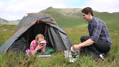 Hombre-Entregándole-A-Su-Novia-Un-Plato-De-Sopa-En-Un-Viaje-De-Campamento