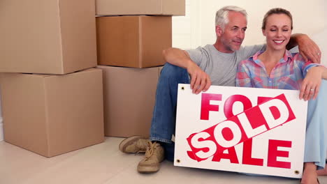 Couple-sitting-beside-cardboard-boxes-and-chatting