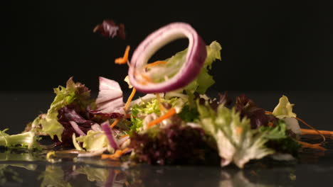 Salad-falling-onto-black-surface