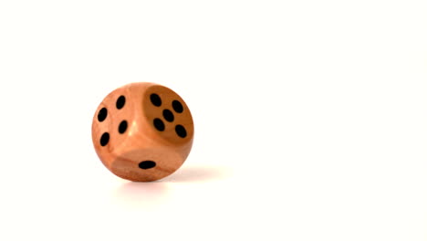 Wooden-dice-spinning-on-white-surface