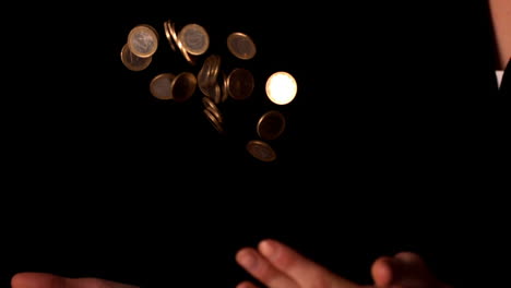 Woman-tossing-euro-coins-on-black-background