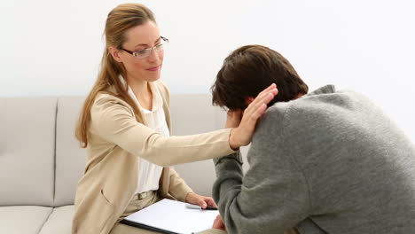 Young-man-sitting-on-sofa-talking-to-his-therapist