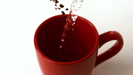 Coffee-granules-and-water-going-into-red-mug
