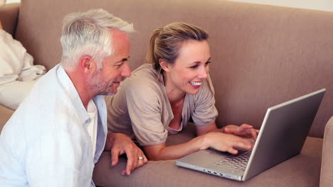 Happy-couple-using-laptop-together-to-shop-online