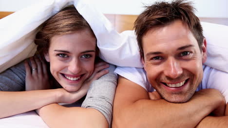 Happy-couple-lying-under-the-duvet