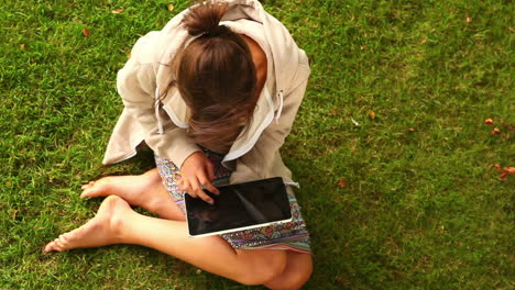 Estudiante-Trabajando-Con-Tablet-Pc-Sentado-En-El-Césped