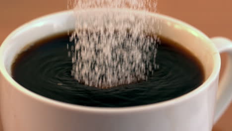 Sugar-pouring-into-cup-of-coffee