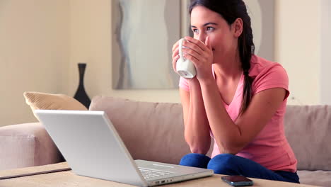 Hübsche-Brünette-Sitzt-Auf-Dem-Sofa-Mit-Ihrem-Laptop