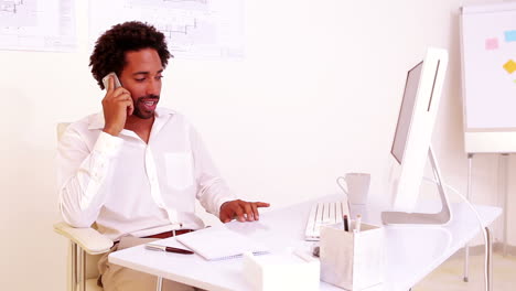 Businessman-talking-on-phone-at-his-desk