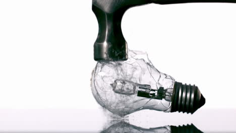 Hammer-smashing-light-bulb-on-white-background