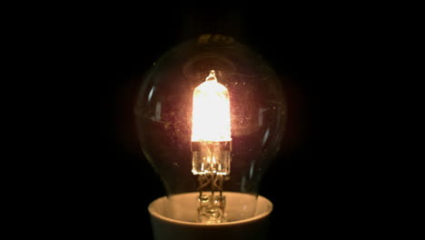 Light-bulb-turning-on-on-black-background