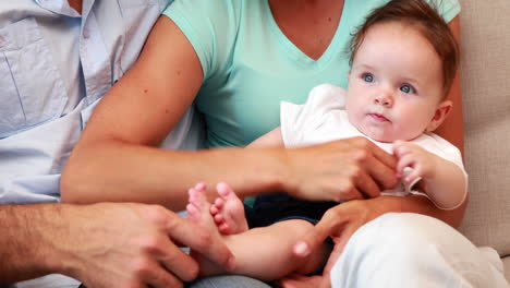 Couple-sitting-on-the-couch-with-their-baby-son