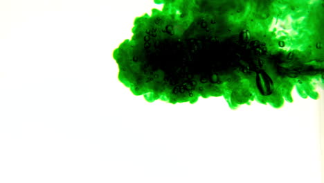 Green-ink-pouring-into-water-on-white-background