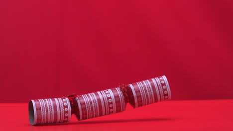 Christmas-cracker-falling-and-bouncing-on-red-background