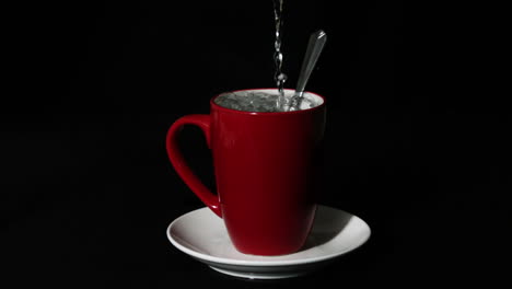 Agua-Caliente-Vertiendo-En-Una-Taza-Roja