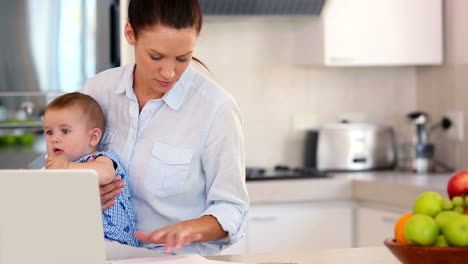 Hübsche-Mutter-Mit-Laptop-Und-Hält-Baby