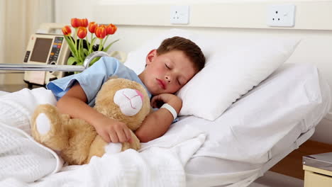 Little-sick-boy-sleeping-in-bed-with-teddy-bear