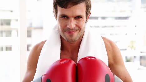 Fit-man-wearing-boxing-gloves-looking-at-camera