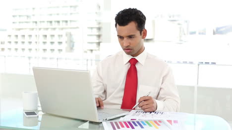 Stern-handsome-businessman-checking-statistics