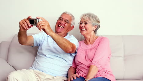 Glückliches-älteres-Paar-Macht-Ein-Selfie-Auf-Der-Couch